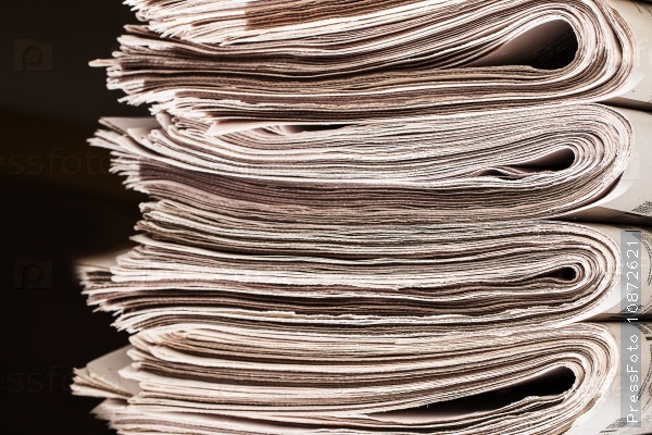 Closeup of a pile of newspapers.  A pile of newspapers