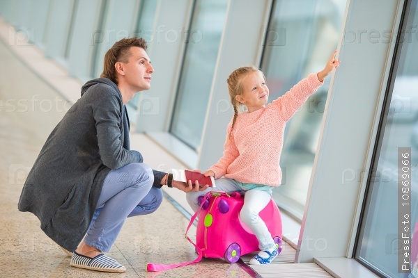 Happy family with luggage and boarding pass at airport waiting for boarding