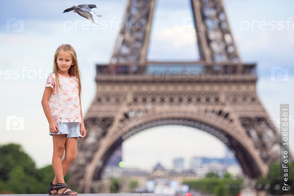 Adorable little girl in Paris background the Eiffel tower during summer vacation