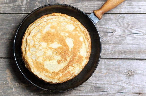 Stack of pancakes on a cast-iron frying pan. Top view. Flat lay