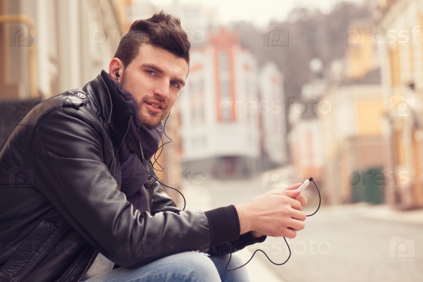 Stylish guy with smartphone in the city