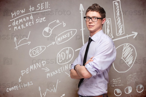 smiling man in glasses near blackboard with economic graphs