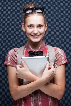 Smiling hipster girl holding tablet PC. Trendy teenager with tablet computer. Checkered red shirt and bow-tie