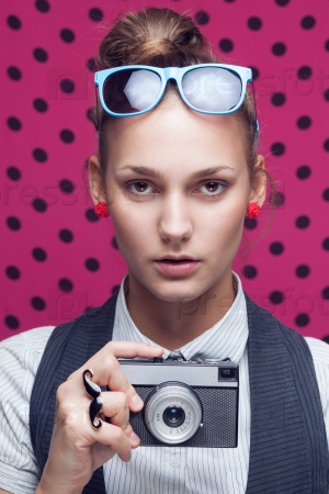 Fashionable teen with old camera in checkered red shirt and bow-tie.