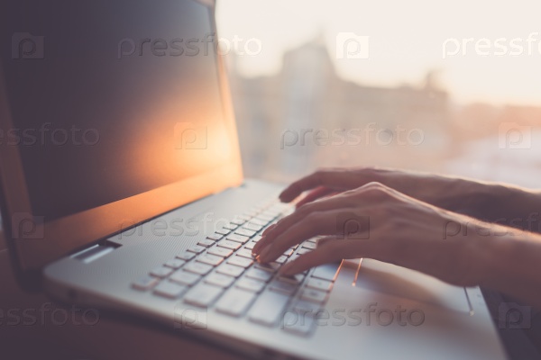 Woman typing on laptop at workplace working in home office hand keyboard.