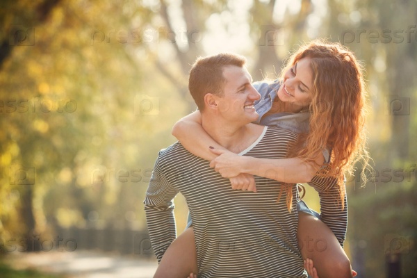 Cheerful couple having fun on summer vacation. Portrait of a happy couple laughing at camera. Young couple in the countryside in autumn. couple having fun outdoor in summer park.