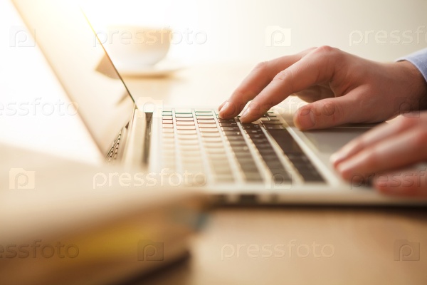 The male hands on the keyboard on the background of table, stock photo