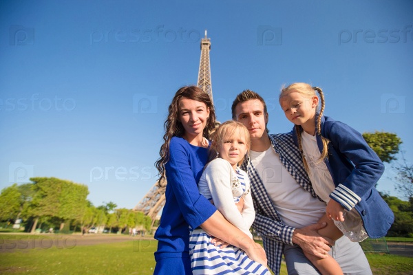 Happy family with two kids in Paris near Eiffel tower. French summer holidays, travel and people concept, stock photo
