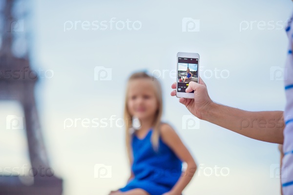 Cute little girl background the Eiffel tower during summer vacation in Paris, stock photo
