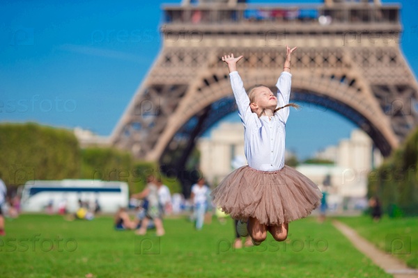 Adorable little girl in Paris background the Eiffel tower during summer vacation, stock photo