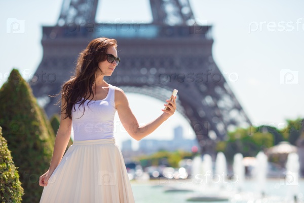 Beautiful woman in Paris background the Eiffel tower during summer vacation, stock photo