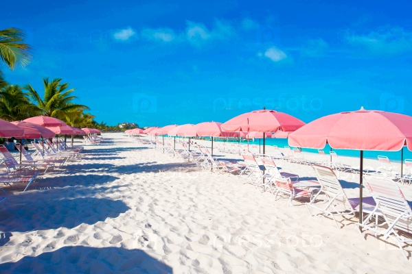 Empty exotic beach and lounges on exotic tropical island at Caribbean sea, stock photo