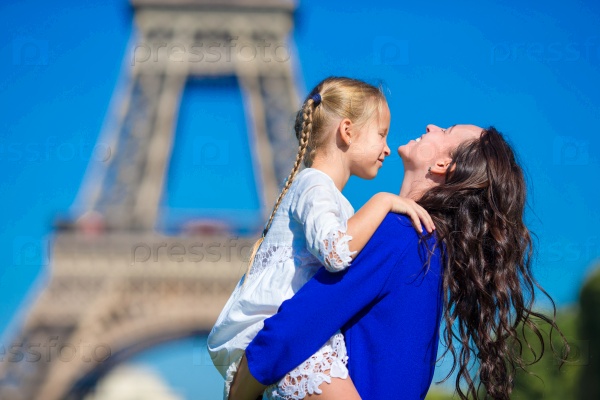 Happy mother and little adorable girl traveling in Paris near Eiffel Tower, stock photo