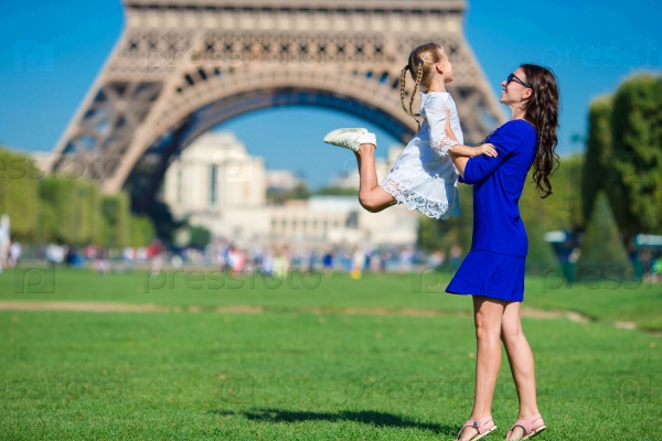 Happy mother and little adorable girl traveling in Paris near Eiffel Tower, stock photo