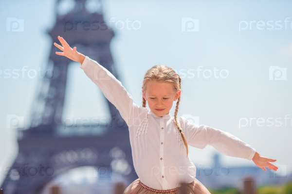 Adorable happy little girl in Paris background the Eiffel tower during summer vacation, stock photo