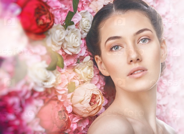 Beautiful young woman on a background of pink flowers. The concept of beauty and health. Beautiful fashion bride, sweet and sensual.
