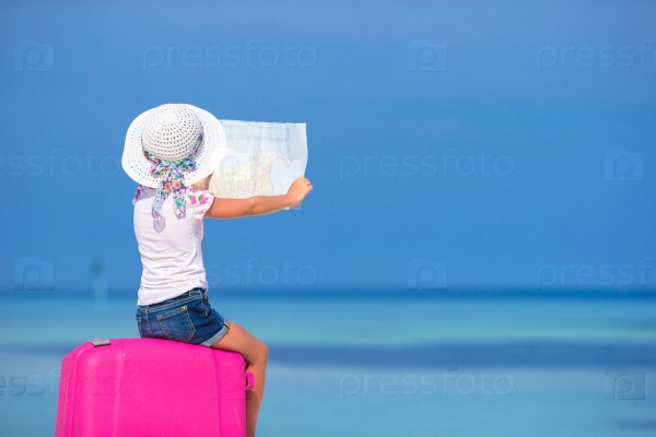 Little adorable girl with big luggage and map of island on white beach