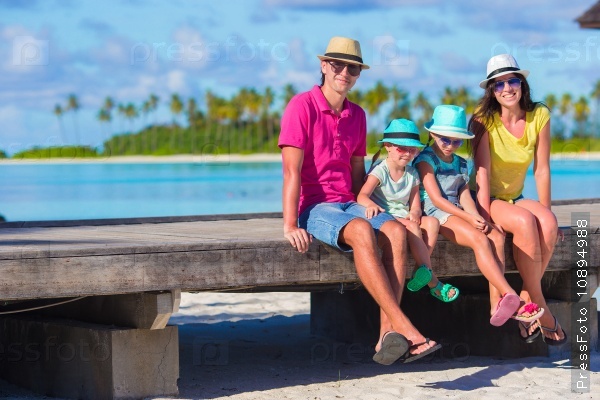Beautiful family of four on beach during summer vacation, stock photo