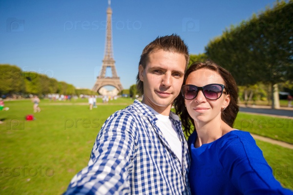 Young happy couple on the Champ de Mars in Paris background the Eiffel Tower, France, stock photo