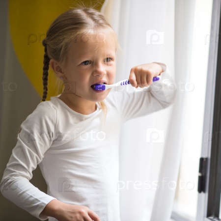 Dental hygiene. Happy little girl brushing her teeth