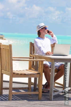 Business man calling by cell phone on white beach