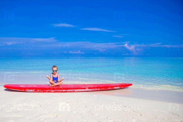 Little girl have fun on surfboard at tropical beach