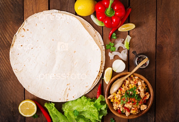 Ingredients for Burritos wraps chicken meat, corn, tomatoes and peppers on wooden background. Top view, stock photo