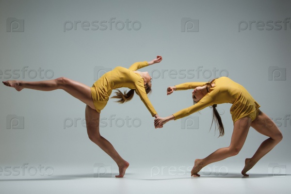 The two modern ballet dancers dancing on gray background, stock photo