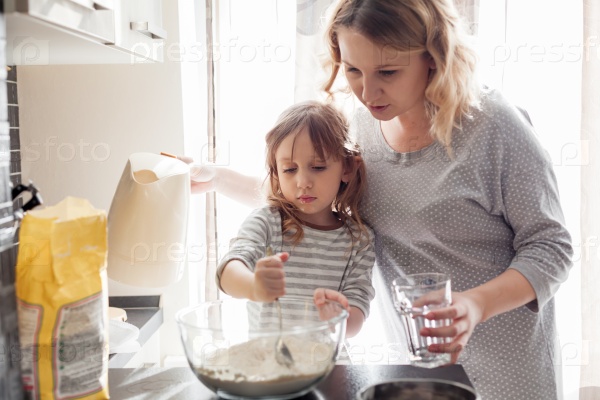 Mom with her 5 years old child cooking holiday pie in the kitchen to Mothers day, casual still life photo series, stock photo