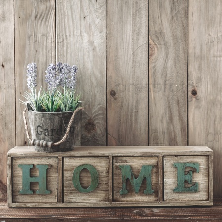 Storage box with Home letters and flowers in a pot on wooden background, home rustic decor, cottage living