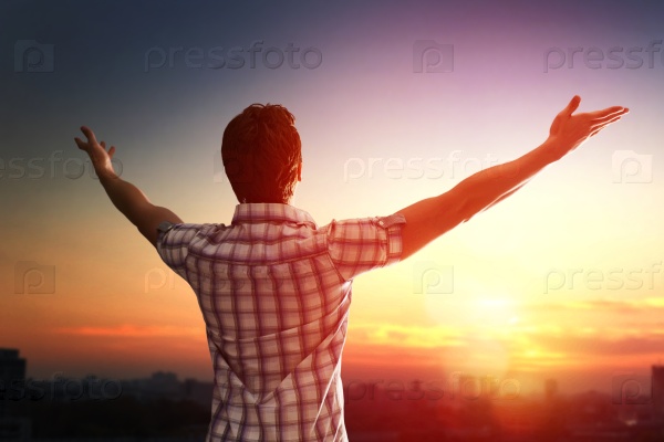 Successful man looking up to sunset sky celebrating enjoying freedom. Positive human emotion feeling life perception success, peace of mind concept. Free happy man, stock photo