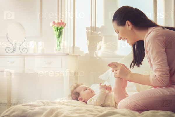 Happy family. mother playing with her baby in the bedroom, stock photo