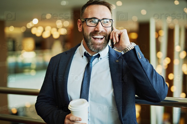 Happy businessman with plastic glass speaking on the phone, stock photo