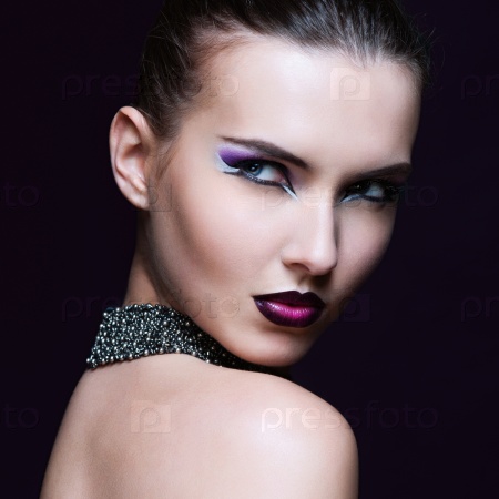 Beauty Woman with Perfect Makeup. Beautiful Professional Holiday Make-up. Purple Lips and Nails. Beauty Girl\'s Face isolated on Black background