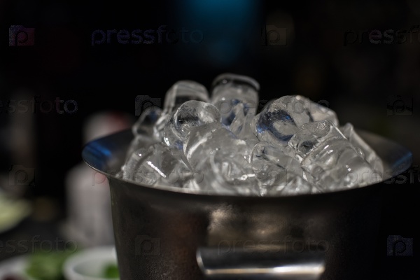 Ice bucket filled with ice cubes closeup, stock photo