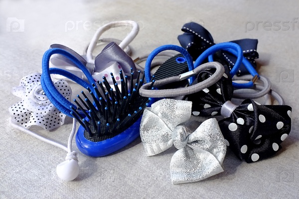 A few elastic hair bands - simple and in the shape of bows and flowers - and a small hair-brush, stock photo
