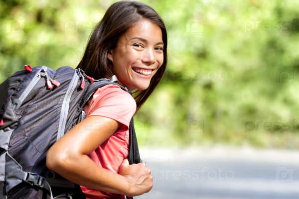 Happy young Asian Chinese backpack girl student. Cute adult woman backpacker smiling at camera with school bag doing summer backpacking travel in nature.