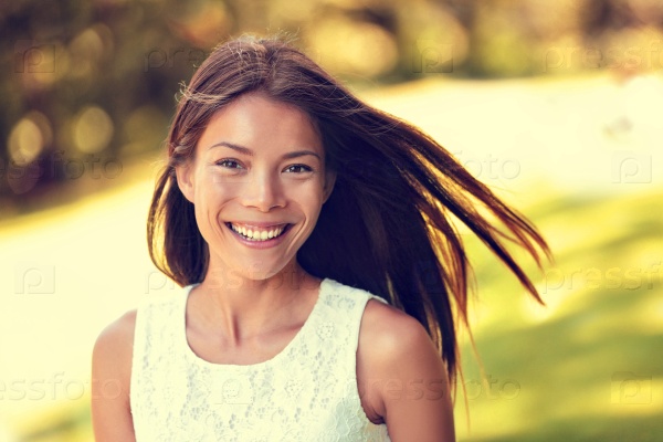 Confident young Asian Chinese beauty woman smiling. Beautiful portrait of healthy female adult in sunny summer grass park background for spring, summertime or pollen allergy season concept.
