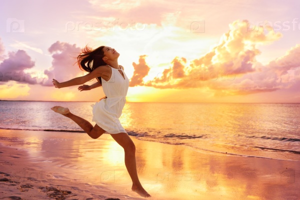 Счастливая девушка бежит по пляжу на закате
