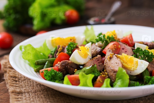 Warm salad with chicken liver, green beans, eggs, tomatoes and balsamic dressing, stock photo