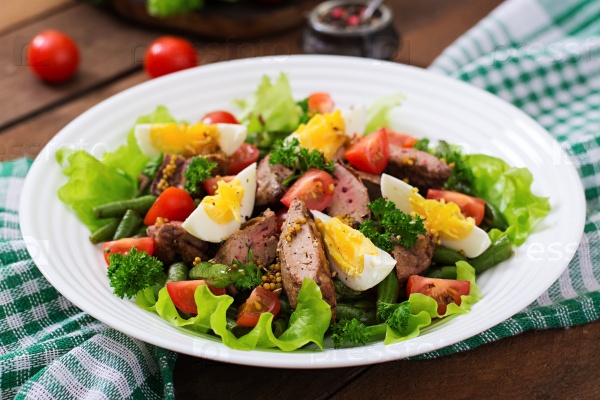 Warm salad with chicken liver, green beans, eggs, tomatoes and balsamic dressing, stock photo