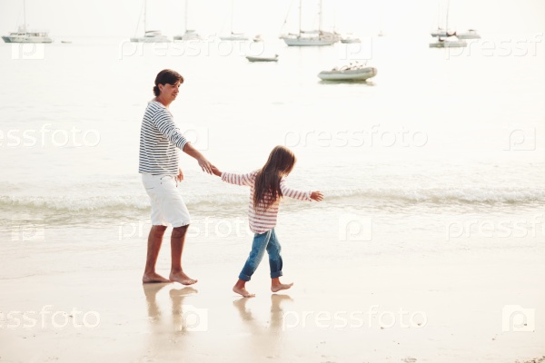 Family walking on the evening beach during sunset, travel photo series, stock photo