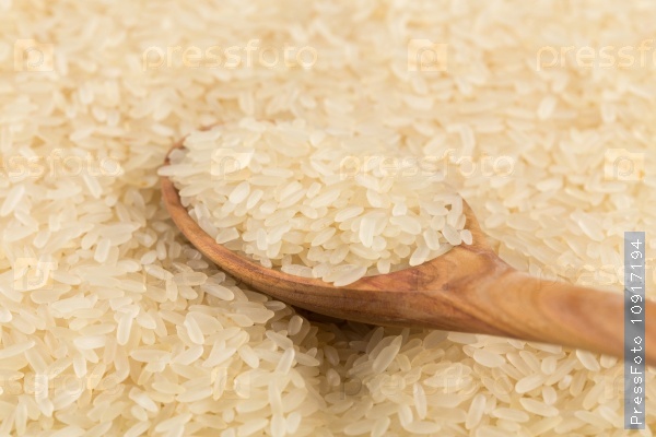 Spoon of rice on puffed rice cereal background close up, stock photo