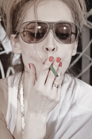 Woman with a cigarette wearing sunglasses