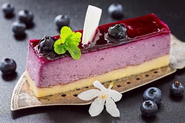 Portion of blueberry mouse cake on old antique cake slicer , stock photo