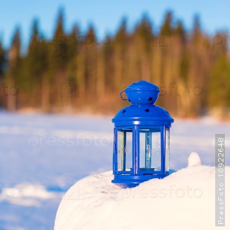 Beautiful red fairytale lantern on snow in forest, stock photo