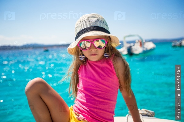 Cute little girl enjoying sailing on boat in the open sea