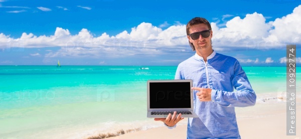 Young man with laptop during beach vacation