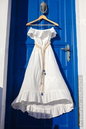 White dress on blue door in greek house