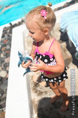 Adorable little girl near pool during greek vacation in Santorini